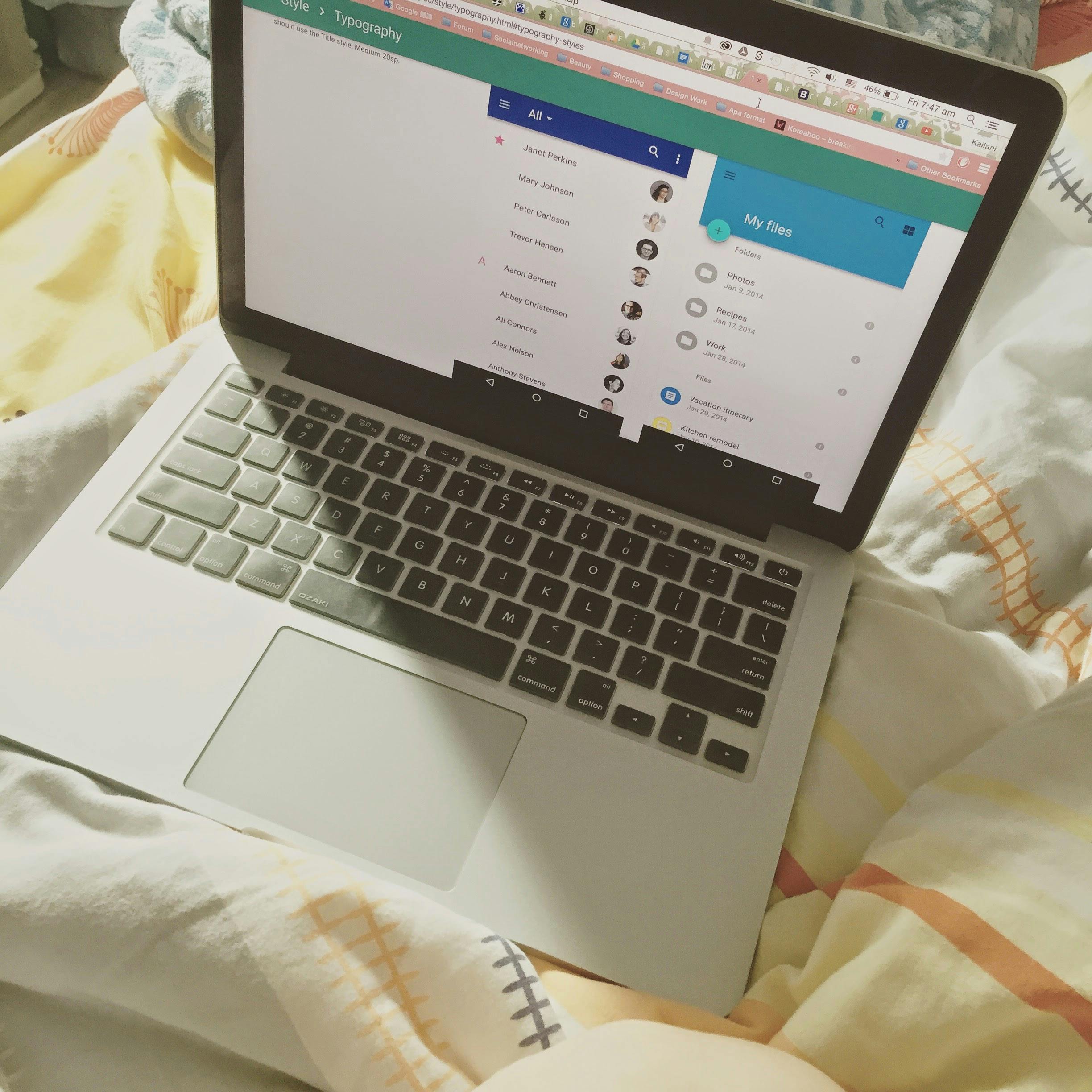 A laptop showing a social media interface on a bed, top view, showcasing technology use in a cozy setting.